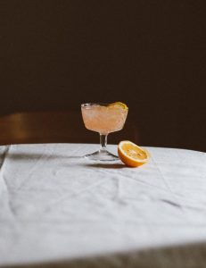 Bicchiere di aranciata con ghiaccio e fetta d'arancia
